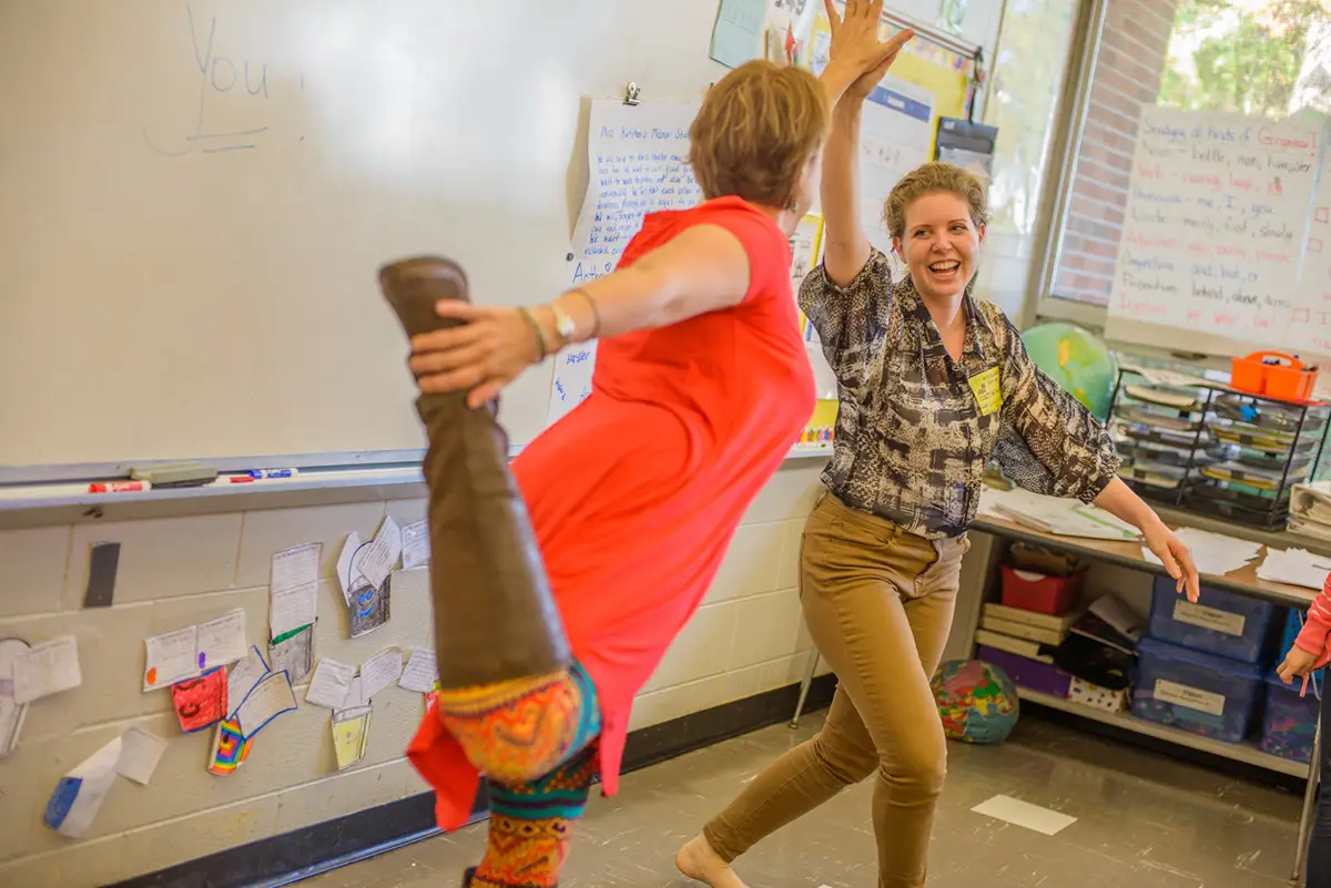two teachers doing yoga in a classroom
