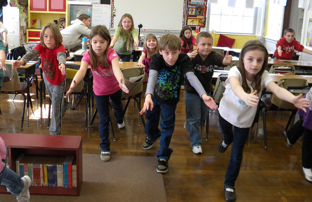 Classroom of elementary students doing yoga show the successfulness of yoga in schools